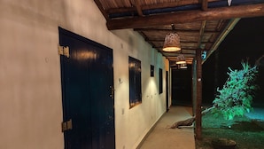 A hallway with dark blue doors, a tiled floor, and a small garden area with a plant illuminated by green lighting. - House with sand court 100m from the beach (Praia da Boracéia São Sebastião)