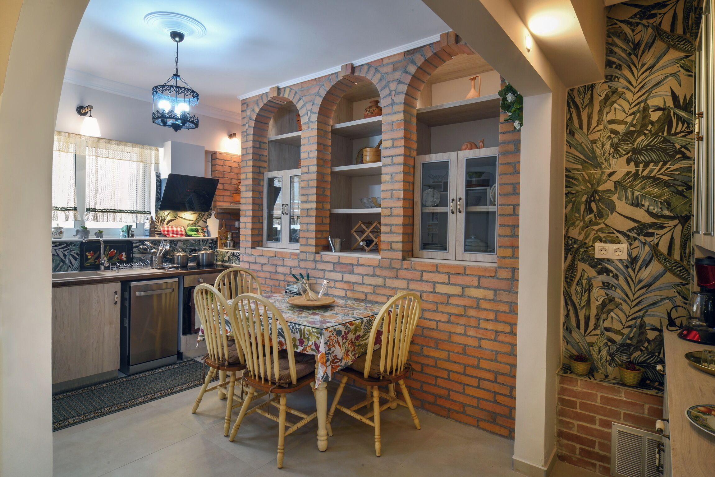 A kitchen with a dining table, chairs, and a brick wall.