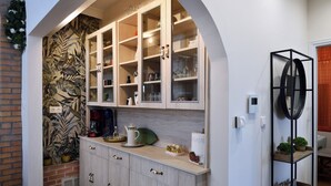 A kitchen with wooden cabinets, a countertop, and a backsplash with a leaf pattern.