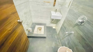 A small, compact bathroom with a toilet, sink, and shower. - Hotel Shri Salasar (Ujjain)