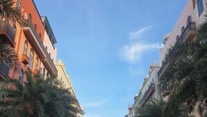 A street lined with palm trees and buildings, featuring a mix of residential and commercial properties. -  Ruby Ha Long 6 Hotel (Bai Chay)