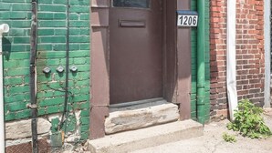 A brown door with a window, a green door, and a brick wall. - Cozy&Modern 2Bdr Apt PIttsburgh (Pittsburgh)