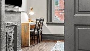 A room with a dining table, chairs, a lamp, and a window with a view of a brick building. - Cozy&Modern 2Bdr Apt PIttsburgh (Pittsburgh)