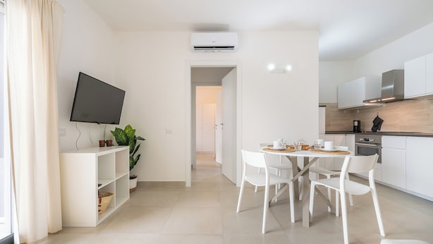 Apartamento moderno e bem iluminado, com área de jantar, cozinha e sala de estar.