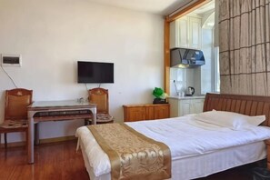 A hotel room with a bed, a desk, a television, a mirror, and a window. - Tangwang Xing'an Stone Forest Hotel (Tangwang County)