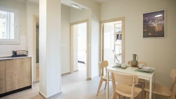 Un espace de vie lumineux et décloisonné, comprenant une cuisine, une table à manger et des chaises.