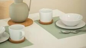 Une table avec un vase, une tasse, un bol et une cuillère.