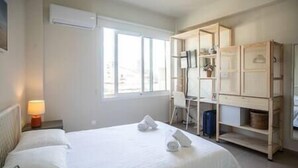Une chambre d’hôtel avec un lit, un bureau et une armoire.