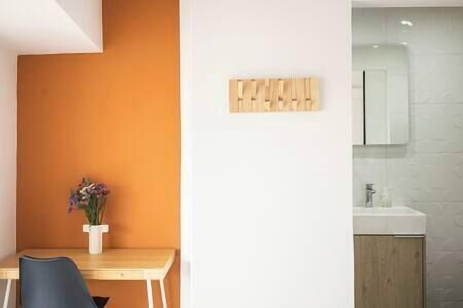 A modern bathroom with a wooden cabinet, a white sink, and a mirror.