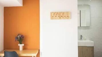 A modern bathroom with a wooden cabinet, a white sink, and a mirror.