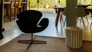 Un intérieur moderne avec un coin repas, une vue sur la piscine et un plafond en bois.