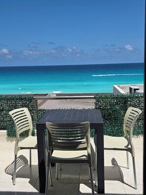 A table and chairs with a view of the ocean.