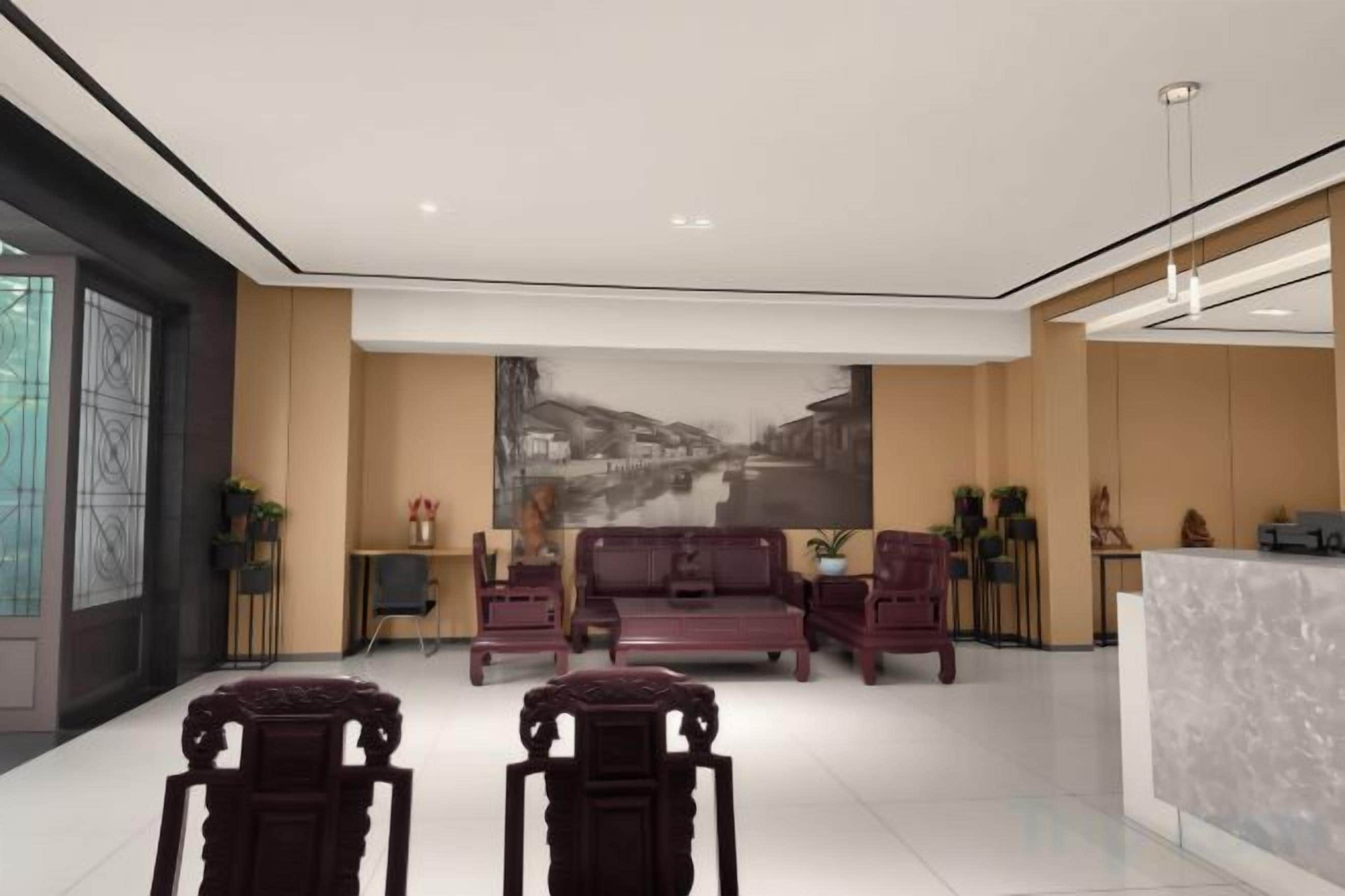 A modern lobby with a reception desk, seating area, and a large wall mural.