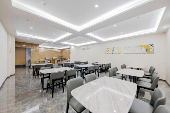 A modern dining area with marble tables and chairs, recessed ceiling lighting, and abstract wall art. - Chenchen Hotel (Yuyao Fengshan Road Zhedong Furniture City) (Yuyao)