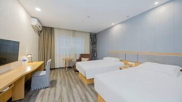 A hotel room with two beds, a desk, a chair, a TV, and a window with curtains.