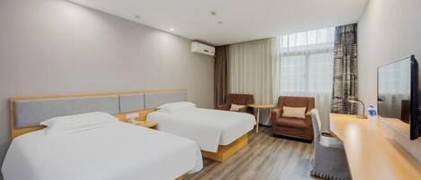 Une chambre d’hôtel avec deux lits, un bureau, une chaise et un téléviseur.