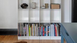 A white bookshelf with various decorative items and books. - The Burrow at Wrigley (Chicago)