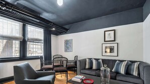 A modern living room with a sofa, chairs, a coffee table, and artwork on the walls. - The Burrow at Wrigley (Chicago)