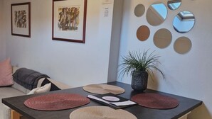 A modern kitchen with a central island, stools, a potted plant, and wall-mounted mirrors. - Cosy room with minikitchen in charming Miðvágur, close to the airport. (Miðvágur)