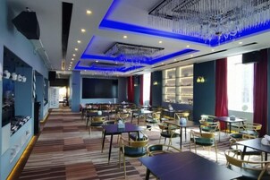 Un restaurante con mesas y sillas, una zona de bar y un candelabro.