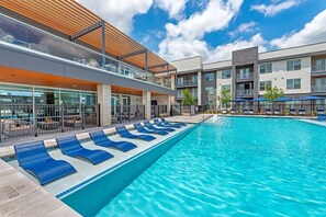 Relax by the pool surrounded by a patio area with comfortable lounge chairs.