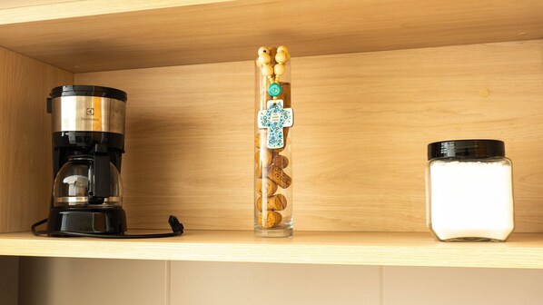 A kitchen shelf with a coffee maker, a decorative bottle with corks, and a jar of sugar. - Makia Beach Experience Porto de Galinhas (Ipojuca)