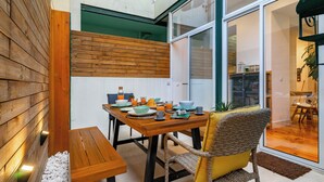 Un comedor con una mesa y sillas de madera, un banco y una planta en maceta.