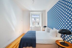 A bedroom with a bed, a bedside table, a lamp, and a window. - Alecrim 43 Top Location Perfect To Explore Lisbon (Lisbon)