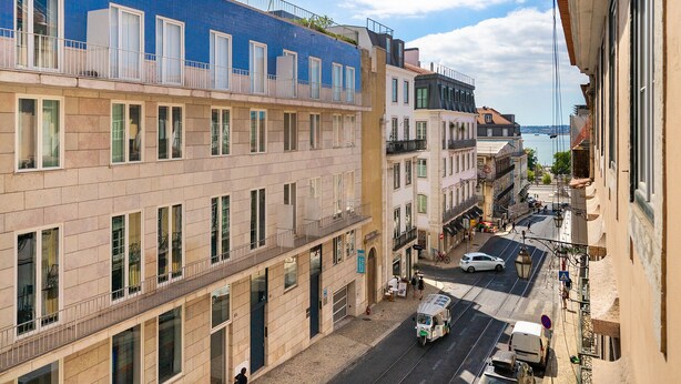 A street view with buildings, a tram, and a car. - Alecrim 43 Top Location Perfect To Explore Lisbon (Lisbon)