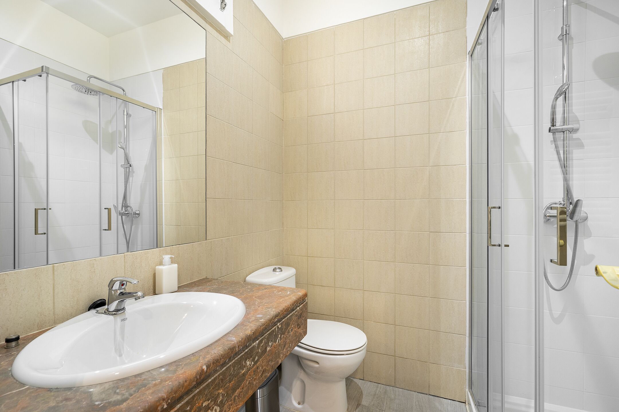 A bathroom with a sink, toilet, and shower.