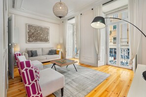A living room with a sofa, armchairs, a coffee table, and a chandelier. - Luxury Stay In Prime Location W/ Ac, Lift & Private Patio (Lisbon)