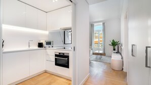 A modern kitchen with white cabinetry, a built-in oven, and a microwave. - The Boulevard Prime Location W/ Elevator (Lisbon)