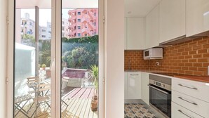 Una cucina moderna con mobili bianchi, un forno a microonde e uno schienale piastrellato.