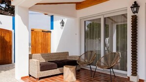 A covered outdoor seating area with a wicker sofa, two wicker chairs, and a small round table. - Countryside Charm Near Wedding Venue W/ Bbq Patio (Torres Vedras)