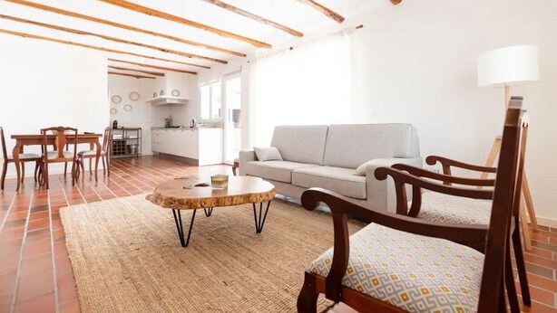 A spacious living area with a wooden ceiling, a sofa, a round coffee table, and a dining table with chairs. - Countryside Charm Near Wedding Venue W/ Bbq Patio (Torres Vedras)