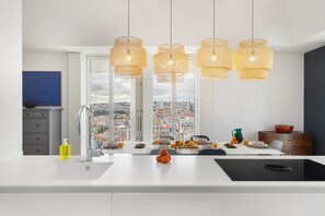 A modern kitchen with a large island, a view of the city, and pendant lights. - Lisbon Skyline Penthouse Luxury Living View, Ac & Elevator (Lisbon)