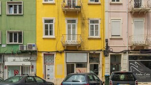 A multi-story building with balconies and a ground-level entrance.