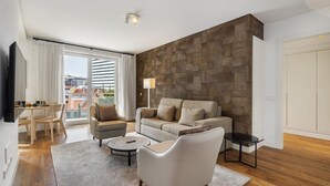 A modern living room with a sofa, armchairs, a coffee table, and a dining area with a table and chairs.