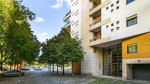 Une rue pavée bordée d’arbres et un bâtiment moderne doté d’une porte de garage.
