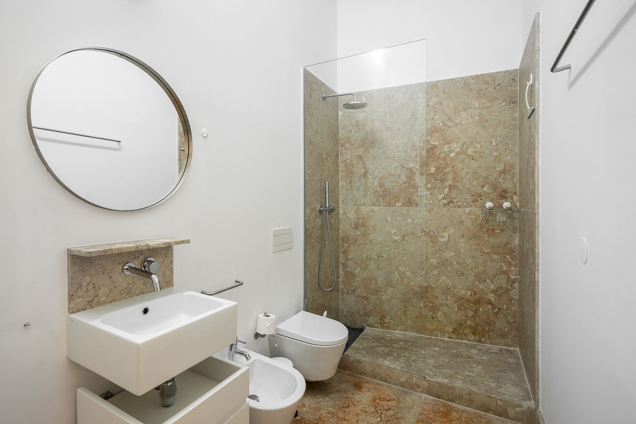 Une salle de bain moderne équipée d’un lavabo, de toilettes et d’une douche.