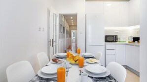 A modern kitchen with white cabinets, a microwave, and a refrigerator. - Mouraria Modern Living Breathtaking Views & Ac (Lisbon)