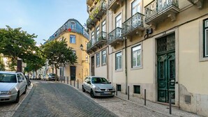 A cobblestone street lined with historic buildings, featuring balconies and traditional architecture. - Mouraria Modern Living Breathtaking Views & Ac (Lisbon)