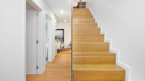 A modern staircase with wooden steps and glass railings, leading to a room with a view. - C314 Riverside View Premium Apartment w/ AC & Terrace (Porto)