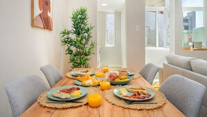 A dining table with breakfast items, chairs, and a potted plant. - Formosa #2 Central 2-Bed In Prime Location Perfect To Explore Porto (Porto)