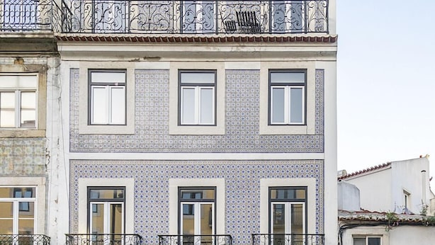 A two-story building with a tiled facade, a ground-floor shop named "GLEBA," and a visible balcony with a railing.