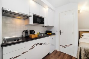 A compact kitchen with a microwave, sink, and modern appliances. - Alfama Studio Prime Location Explore Lisbon W/ Style (Lisbon)