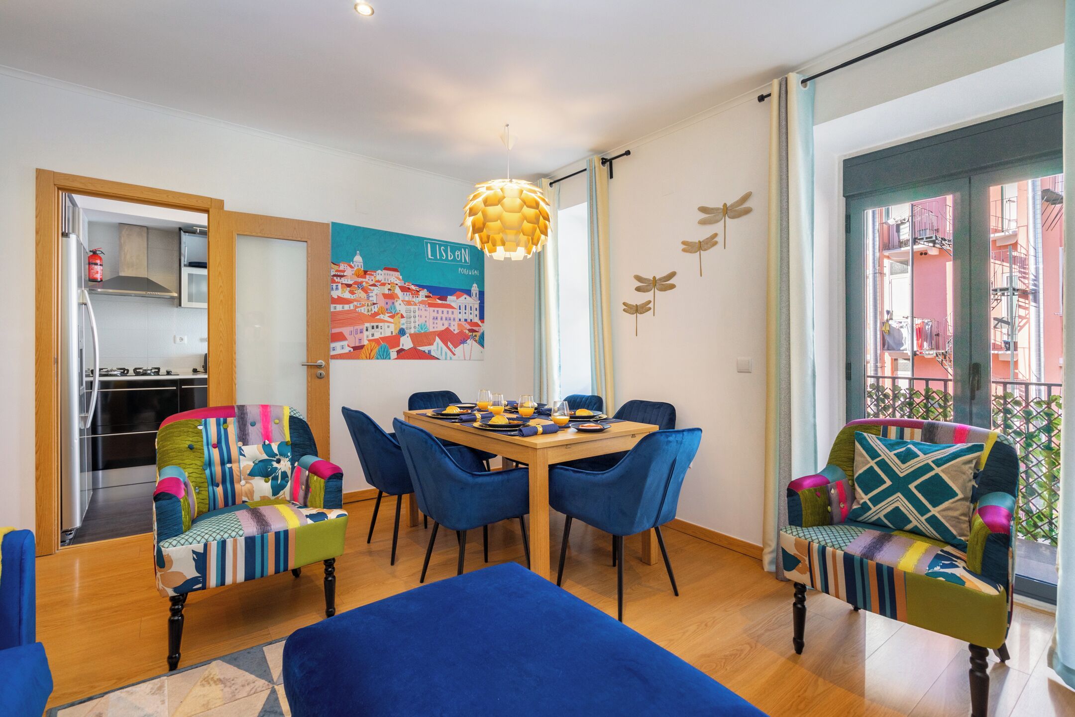 A dining area with a wooden table, blue chairs, and a colorful chair with a patchwork design.