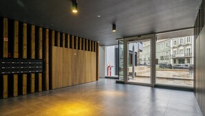 Un interior moderno con un panel de madera, una recepción y una puerta de cristal que da al exterior.