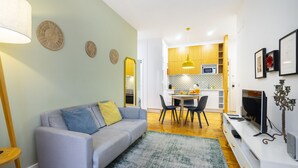 A modern living room with a grey sofa, a coffee table, and a TV stand. - Dreamy Living Your Chic Graça Retreat (Lisbon)
