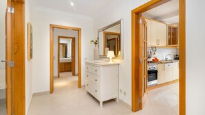 A modern kitchen with white cabinets, a stove, and a sink. - Family Holidays W/ S-Pool, Ac, Elevator & Garage (Loulé)